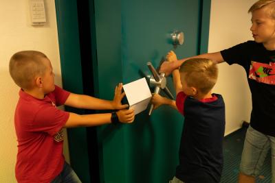 Kinder öffnen die Tresor-Tür der Sparkasse Uckermark